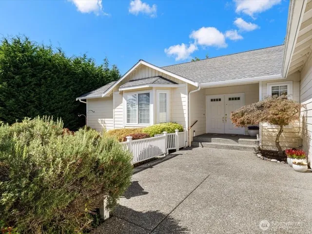 a front view of a house with a yard and potted plants