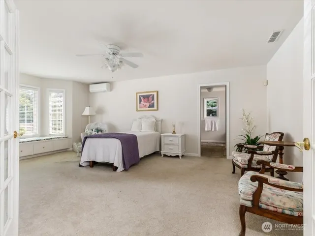 a spacious bedroom with a bed and a chandelier