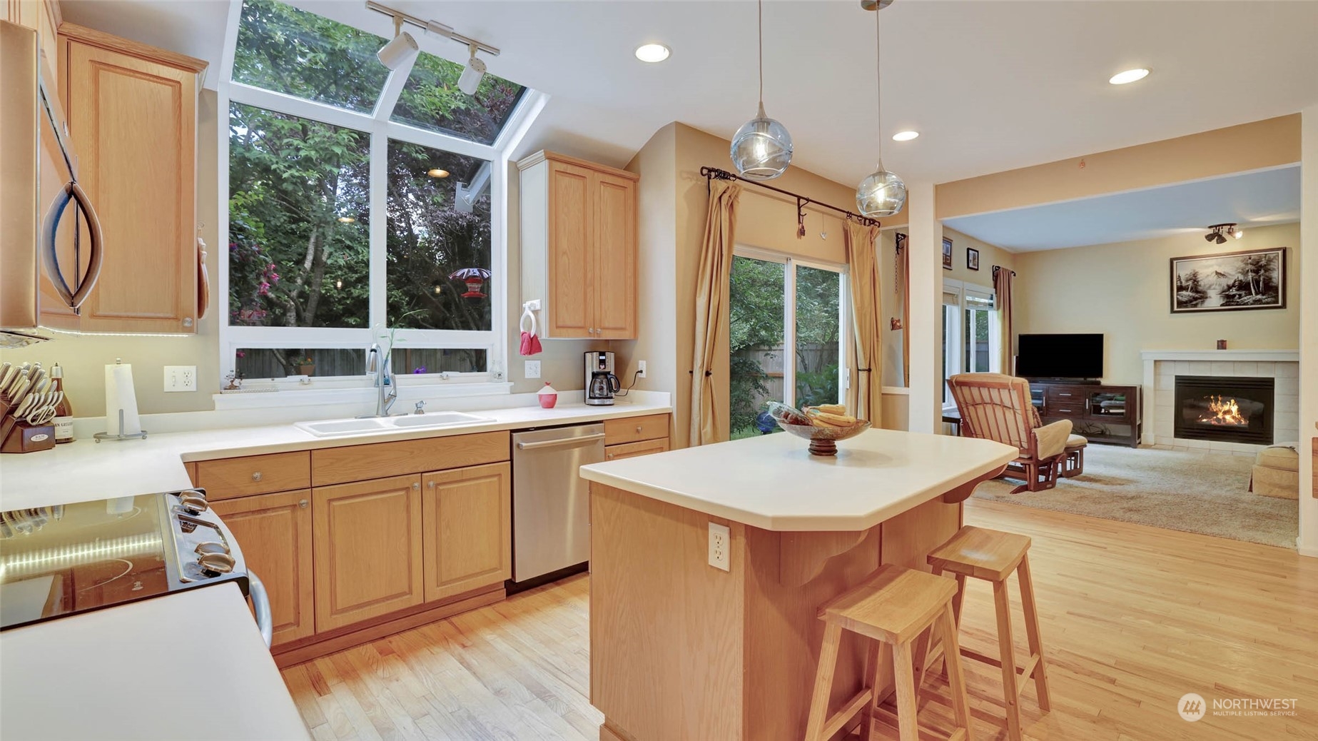 18609 173rd Way Southeast Renton, WA 98058 - Photo 12 of 37 a kitchen with stainless steel appliances sink stove and white cabinets with wooden floor