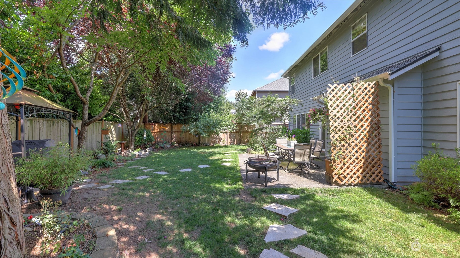 18609 173rd Way Southeast Renton, WA 98058 - Photo 32 of 37 a view of backyard with table and chairs and a large tree