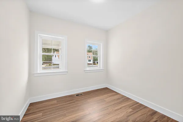 a bathroom with a double vanity sink and mirror with toilet