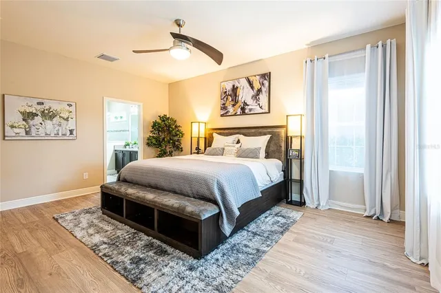 a bedroom with a bed rug and wooden floor