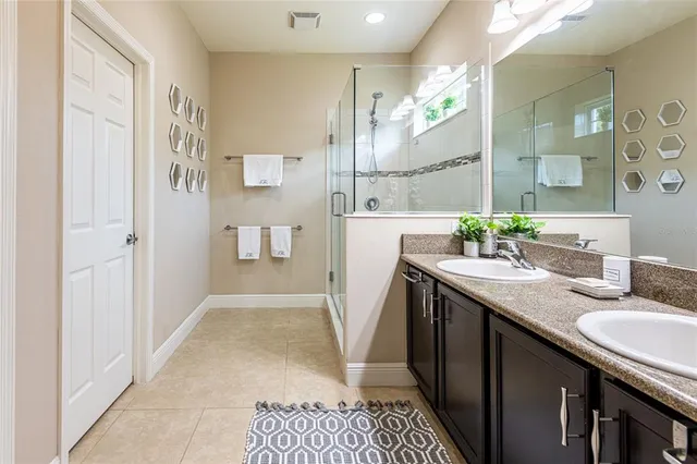 a bathroom with a granite countertop sink a mirror and a shower