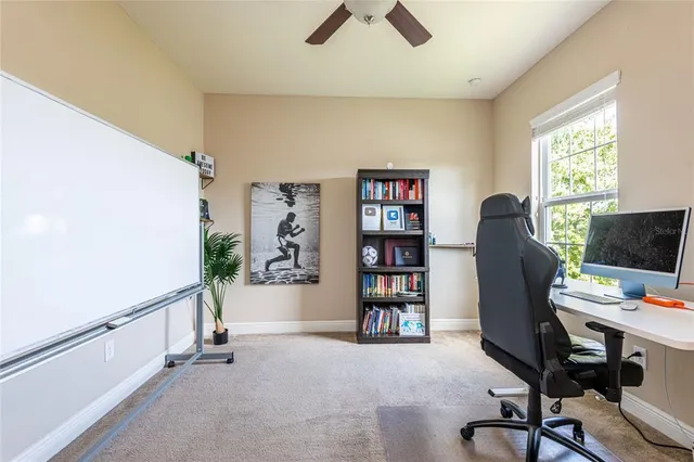 a view of a workspace with furniture and a window