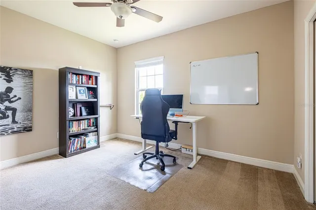 a view of a workspace with furniture and a bookshelf