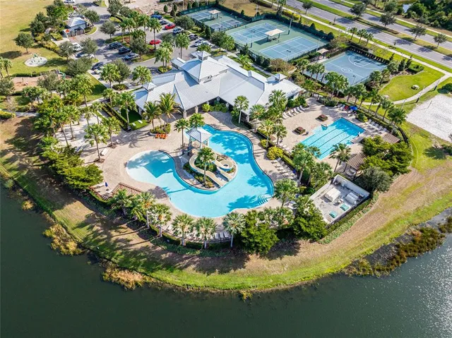a view of a house with a yard and palm trees