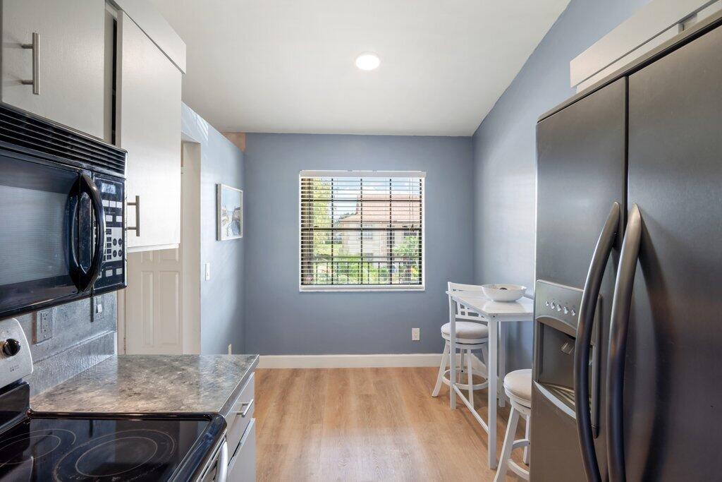 1402 Pinecrest Circle, Unit B Jupiter, FL 33458 - Photo 11 of 56 a kitchen with a table and chairs