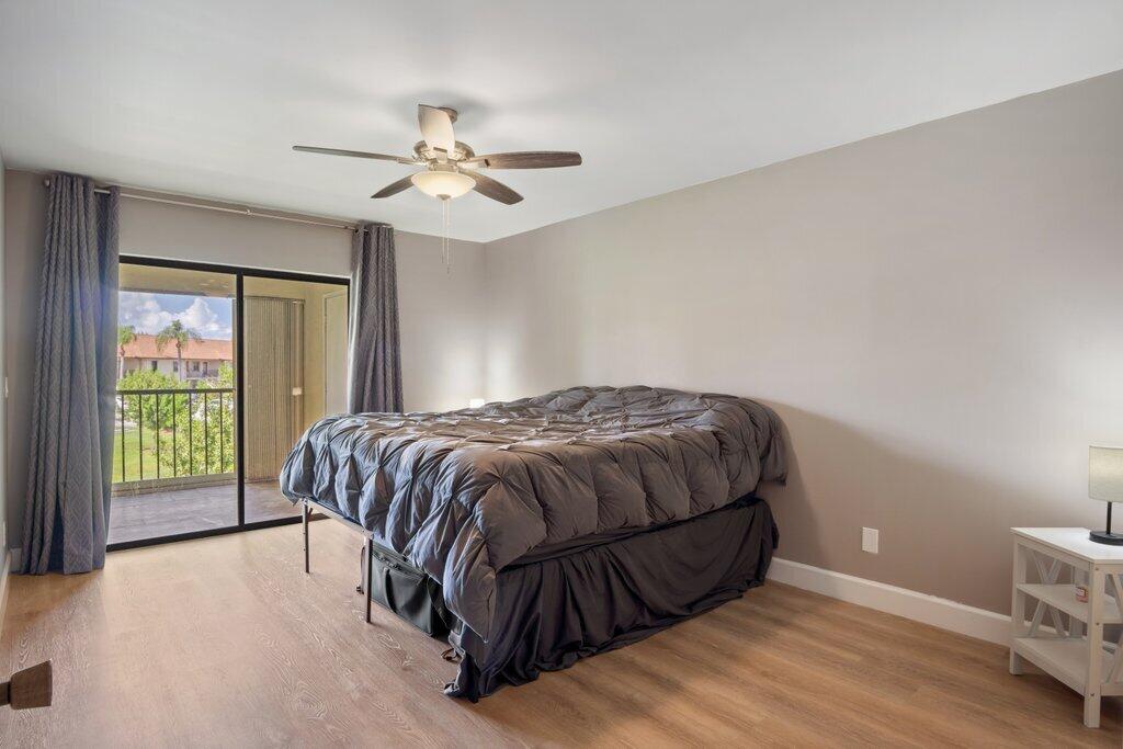 1402 Pinecrest Circle, Unit B Jupiter, FL 33458 - Photo 18 of 56 a bed sitting in a spacious bedroom next to a window