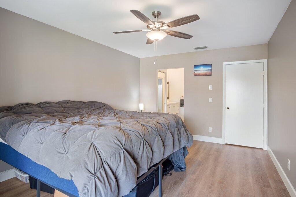 1402 Pinecrest Circle, Unit B Jupiter, FL 33458 - Photo 20 of 56 a bedroom with a bed and a chandelier