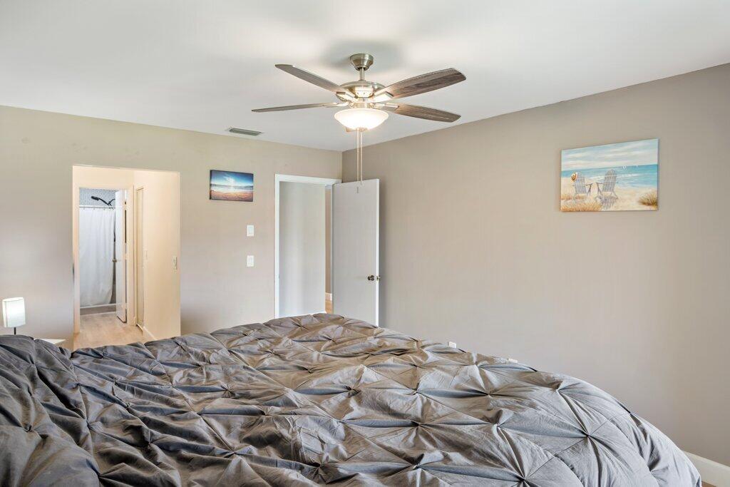 1402 Pinecrest Circle, Unit B Jupiter, FL 33458 - Photo 21 of 56 a bedroom with a large bed and a chandelier