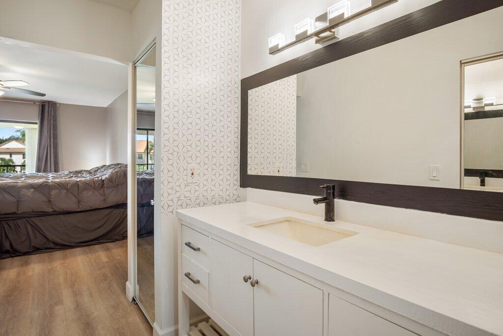 1402 Pinecrest Circle, Unit B Jupiter, FL 33458 - Photo 22 of 56 a bathroom with a sink and a mirror
