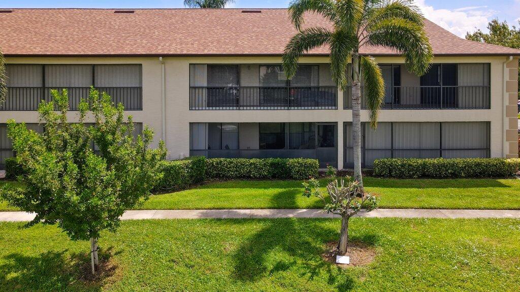 1402 Pinecrest Circle, Unit B Jupiter, FL 33458 - Photo 39 of 56 a front view of a house with a yard and garage