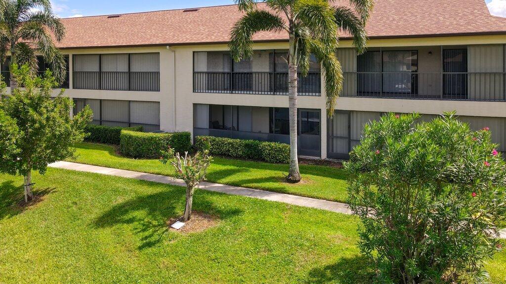 1402 Pinecrest Circle, Unit B Jupiter, FL 33458 - Photo 40 of 56 a house with a big yard and large trees