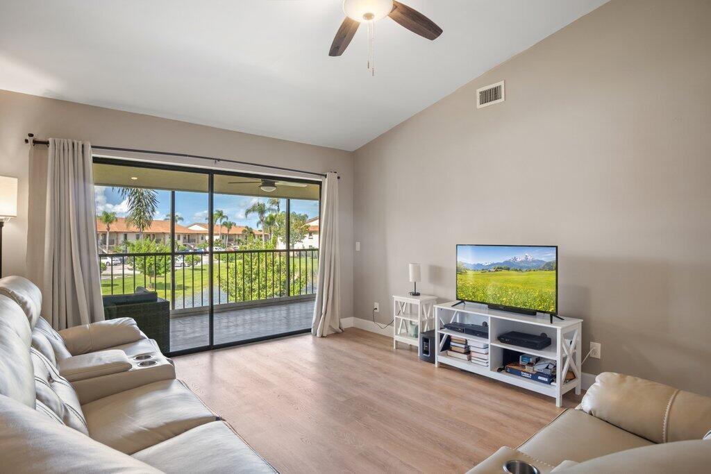 1402 Pinecrest Circle, Unit B Jupiter, FL 33458 - Photo 5 of 56 a living room with furniture and a flat screen tv