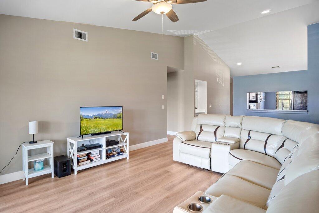1402 Pinecrest Circle, Unit B Jupiter, FL 33458 - Photo 6 of 56 a living room with furniture flat screen tv and wooden floor