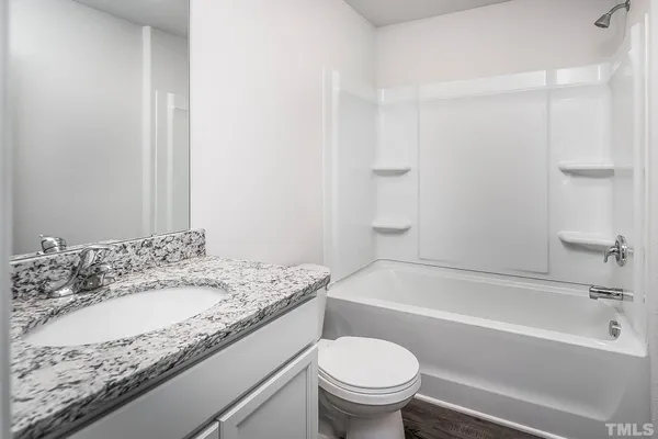 a bathroom with a granite countertop sink a toilet and bathtub