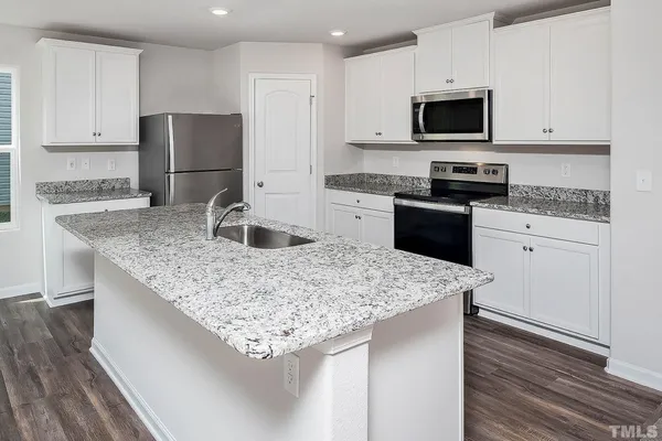 a kitchen with appliances a sink and a refrigerator