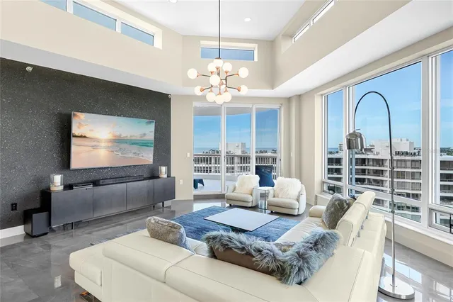 a living room with furniture chandelier and a large window