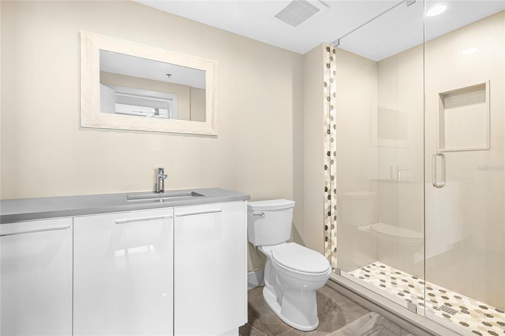 455 Longboat Club Road, Unit PH8 Longboat Key, FL 34228 - Photo 22 of 64 a bathroom with a granite countertop sink a toilet a mirror and shower