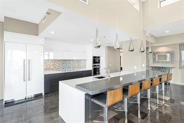 a kitchen with stainless steel appliances granite countertop a sink and a refrigerator
