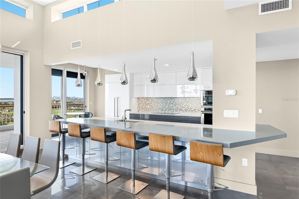 455 Longboat Club Road, Unit PH8 Longboat Key, FL 34228 - Photo 8 of 64 a large living room with stainless steel appliances kitchen island granite countertop furniture and a large window