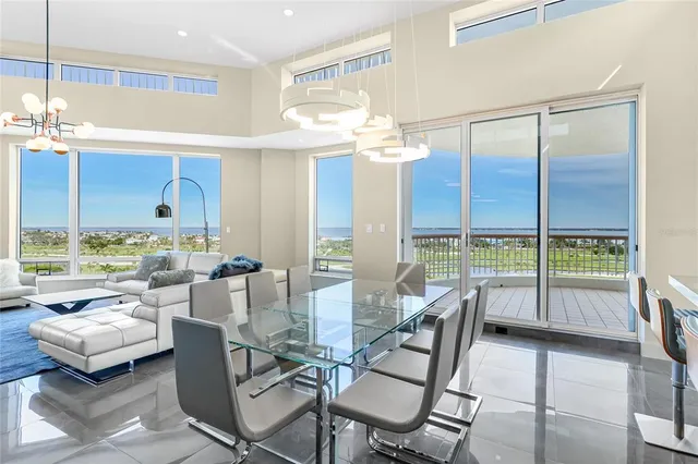 a dining room with furniture and a floor to ceiling window