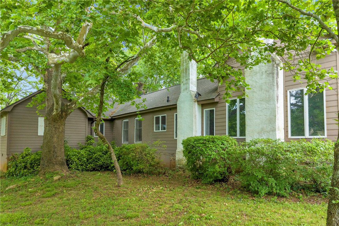 200 Chenault Road Townville, SC 29689 - Photo 29 of 47 Mature trees frame this inviting residence, showcasing its classic siding and well-maintained grounds.