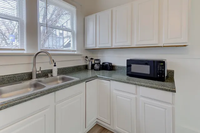 a kitchen with granite countertop a sink and a stove top oven