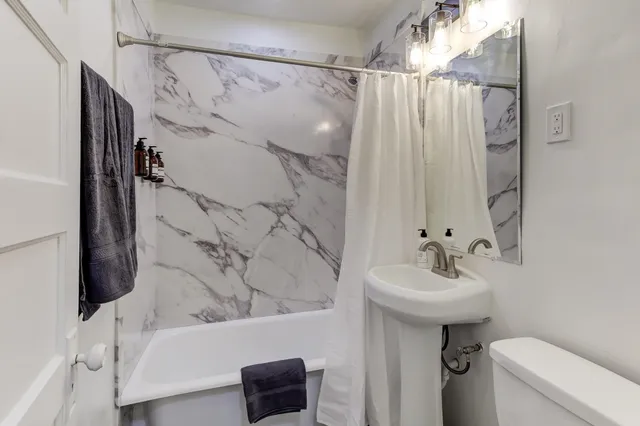 a kitchen with a refrigerator a stove and white cabinets with wooden floor