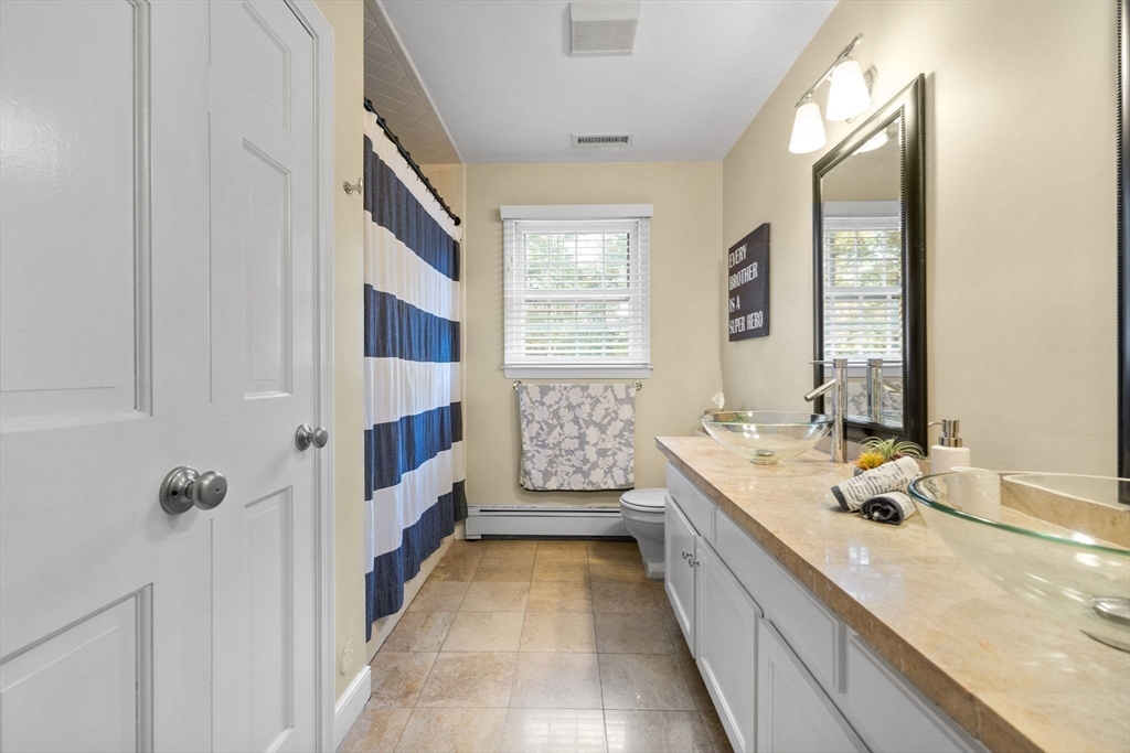 4 Alonesos Way Andover, MA 01810 - Photo 32 of 42 a bathroom with a double vanity sink a mirror and a bathtub