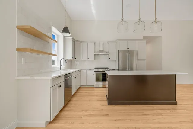 a kitchen with stainless steel appliances a stove a sink and a refrigerator