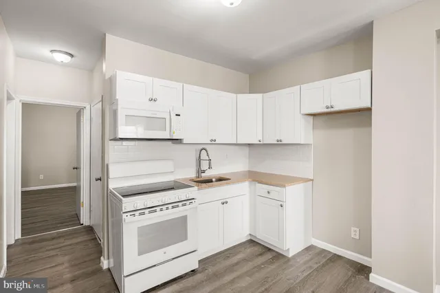 a kitchen with white cabinets and white appliances