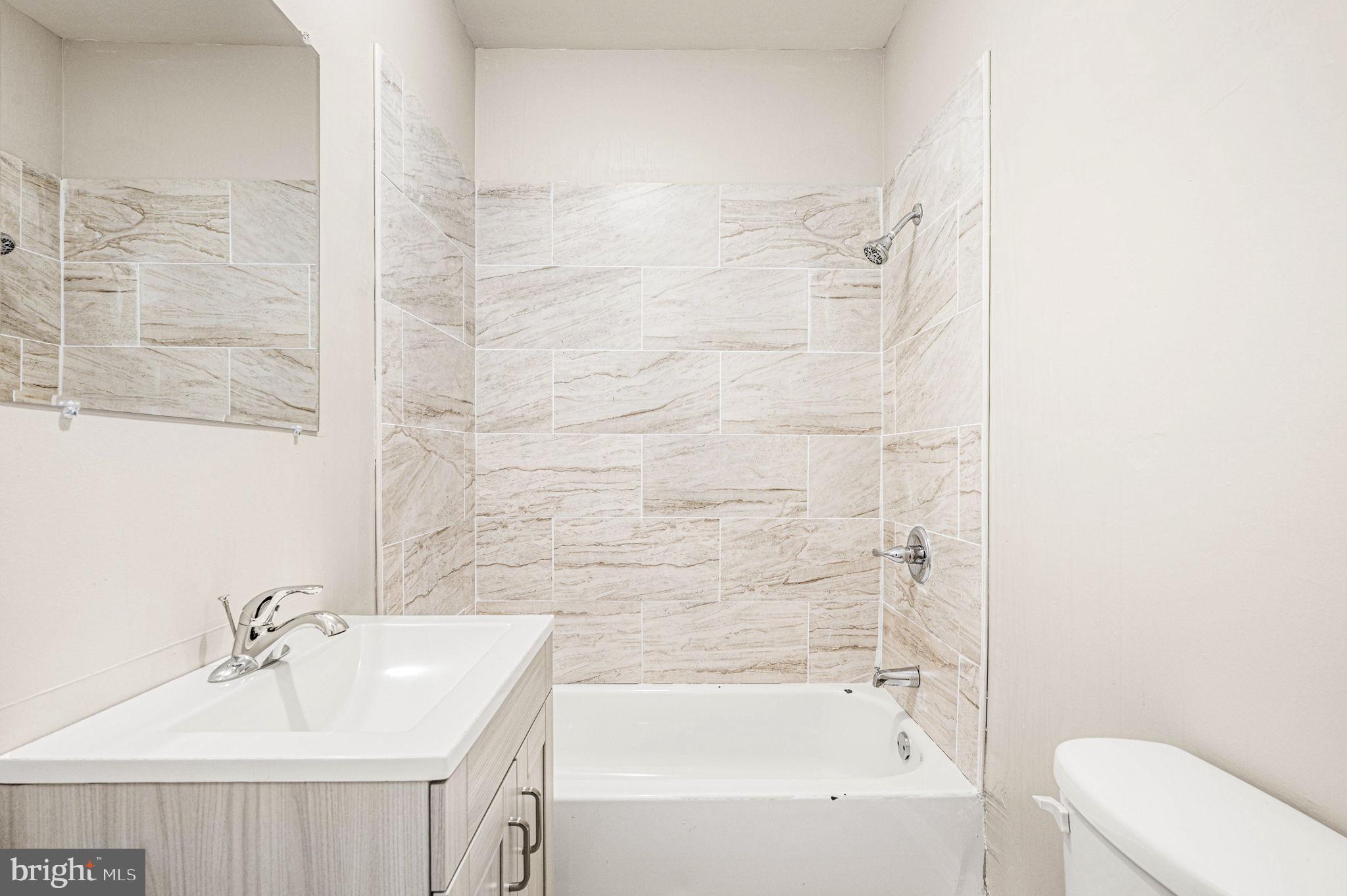 2030 South Cecil Street, Unit 1 Philadelphia, PA 19143 - Photo 8 of 11 a bathroom with a bathtub shower sink and toilet