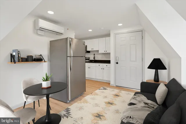 a kitchen with granite countertop a refrigerator a stove a dining table and chair with wooden floor