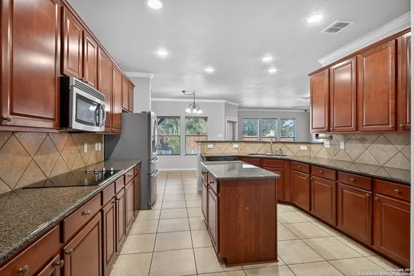 a kitchen with stainless steel appliances granite countertop a sink counter space cabinets and a large window