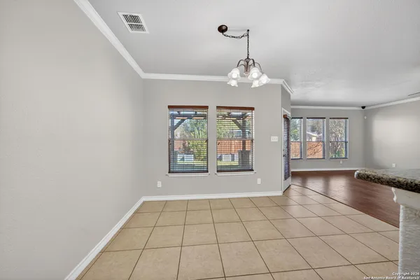 a view of an empty room with window and chandelier