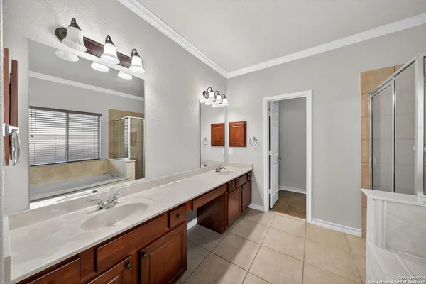 a bathroom with a double vanity sink a mirror and a shower