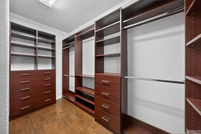 a view of walk in closet with clothes and shoes