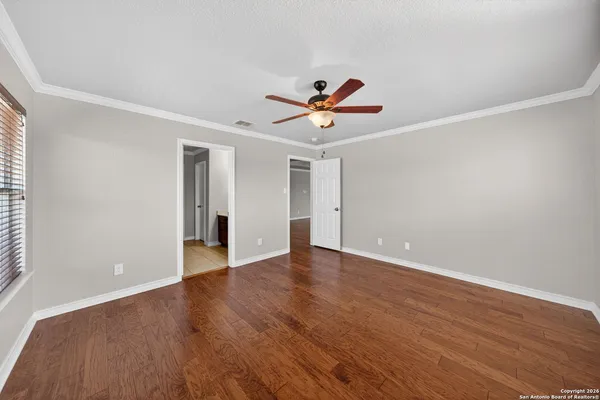 a view of an empty room with window and wooden floor