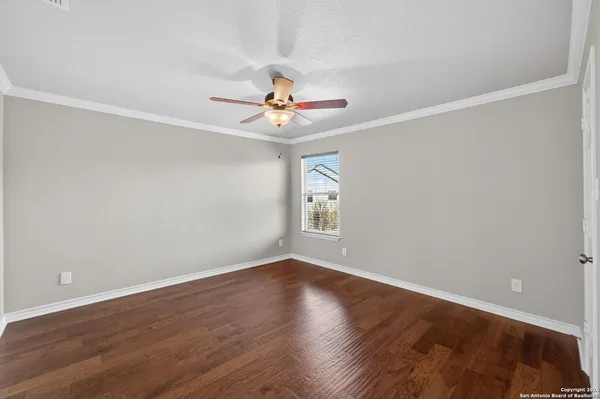 a view of a room with wooden floor and a ceiling fan