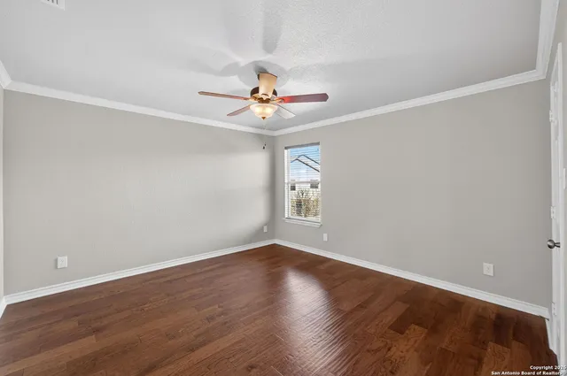 a view of a room with wooden floor and a ceiling fan