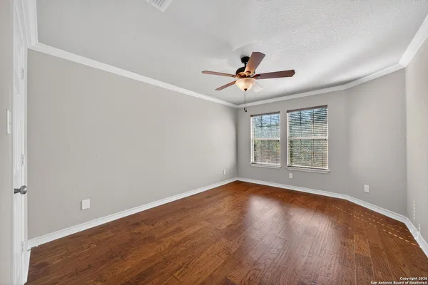 a view of room with hardwood floor and ceiling fan