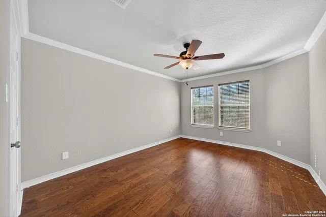 a view of room with hardwood floor and ceiling fan