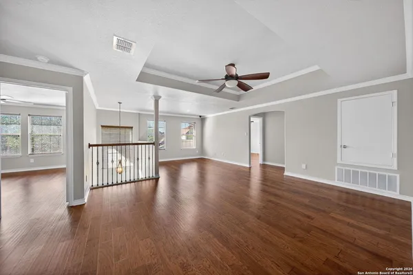 a view of a livingroom with wooden floor and a ceiling fan
