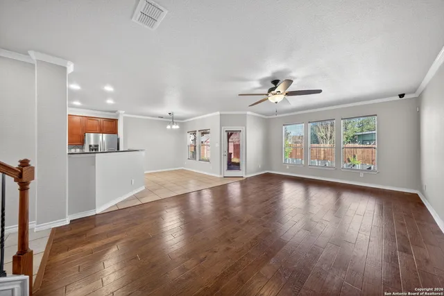 a view of a livingroom with wooden floor and a ceiling fan