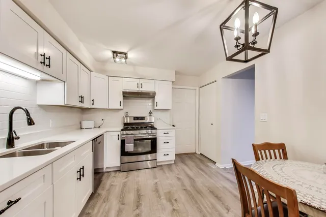 a kitchen with stainless steel appliances a sink stove and cabinets