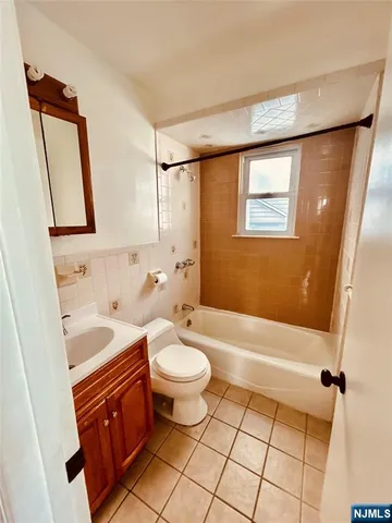 a bathroom with a sink a toilet a mirror a vanity and bathtub