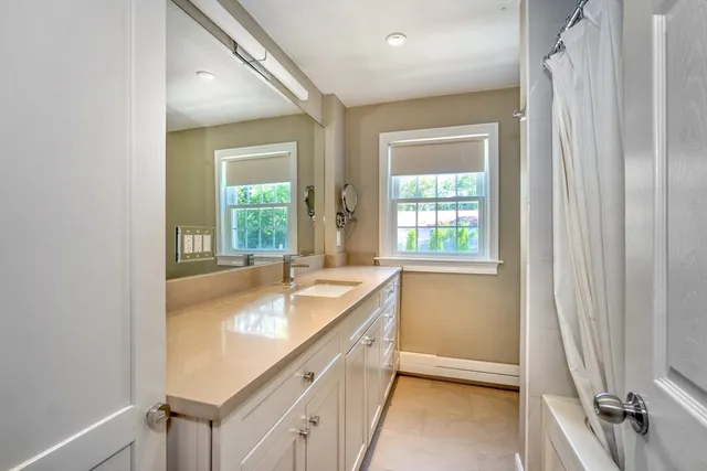 a bathroom with a granite countertop sink and a large mirror