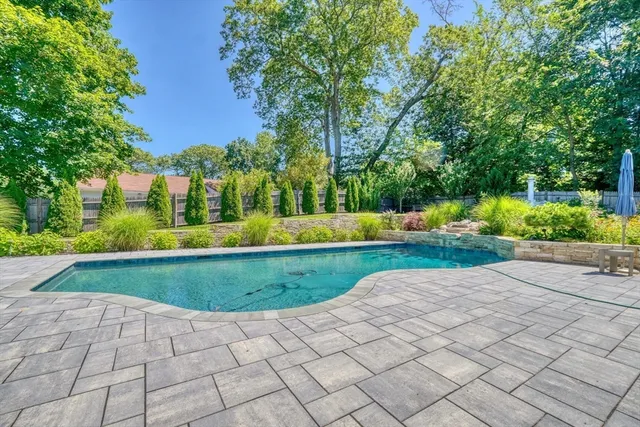 a view of backyard with swimming pool and green space