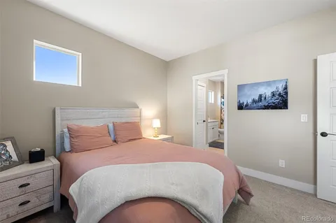 a bedroom with a bed and painting on the wall